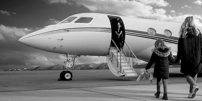 Black and white shot of boarding a jet with cabin crew ready to assist