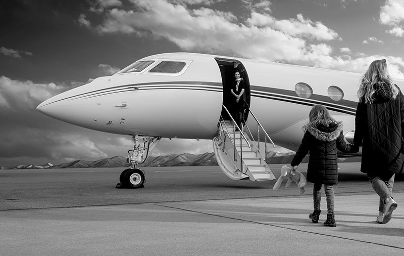 Black and white shot of boarding a jet with cabin crew ready to assist